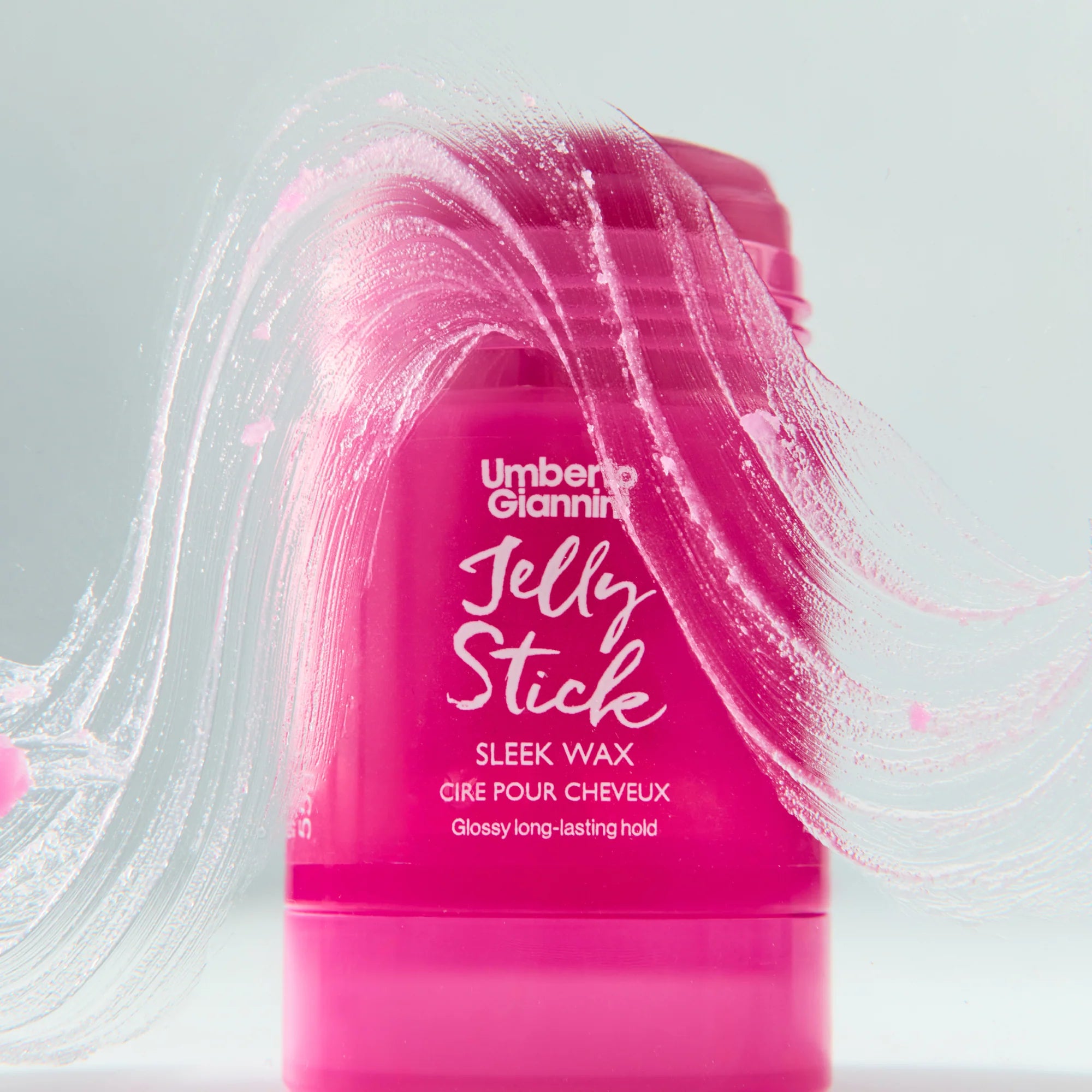 Umberto Giannini Haarwax Stick met glanzende roze waxstrepen, biedt langdurige hold en glans voor krullend en gestyled haar.