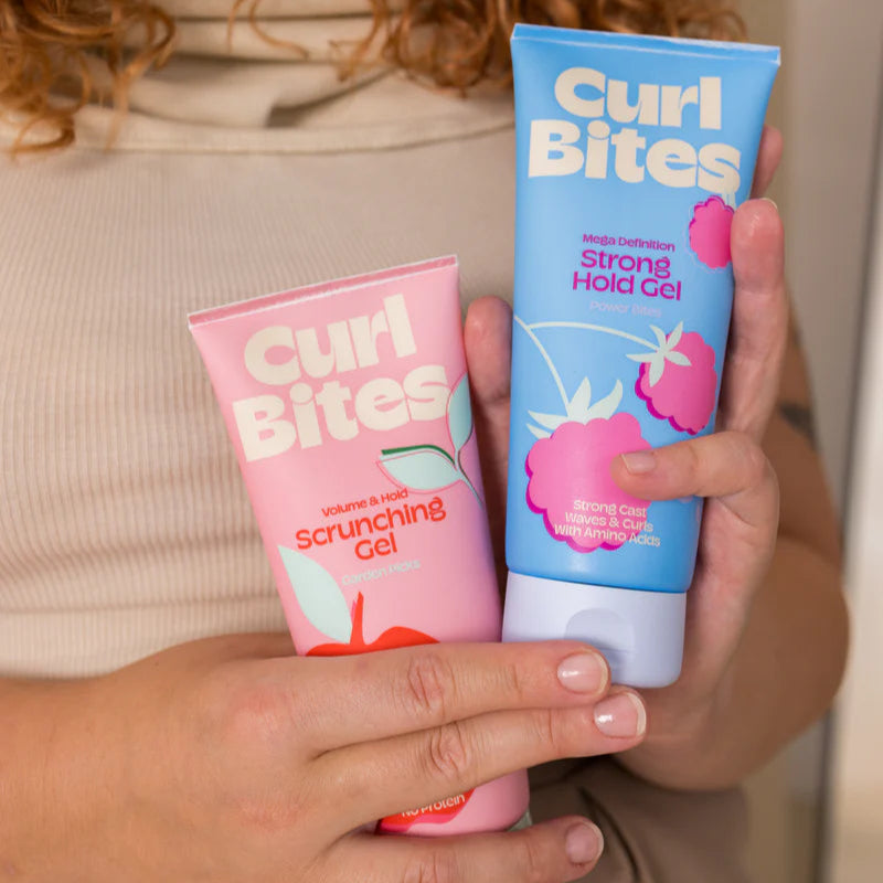 Twee Curl Bites gels in handen, Volume & Hold Scrunching Gel 200ml en Strong Hold Gel, perfect voor CG-method krulstyling.