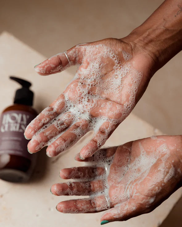 Schuimende Holy Curls Shampoo op handen, toont rijke textuur en reinigende werking voor krullend haar, 300 ml verpakking.