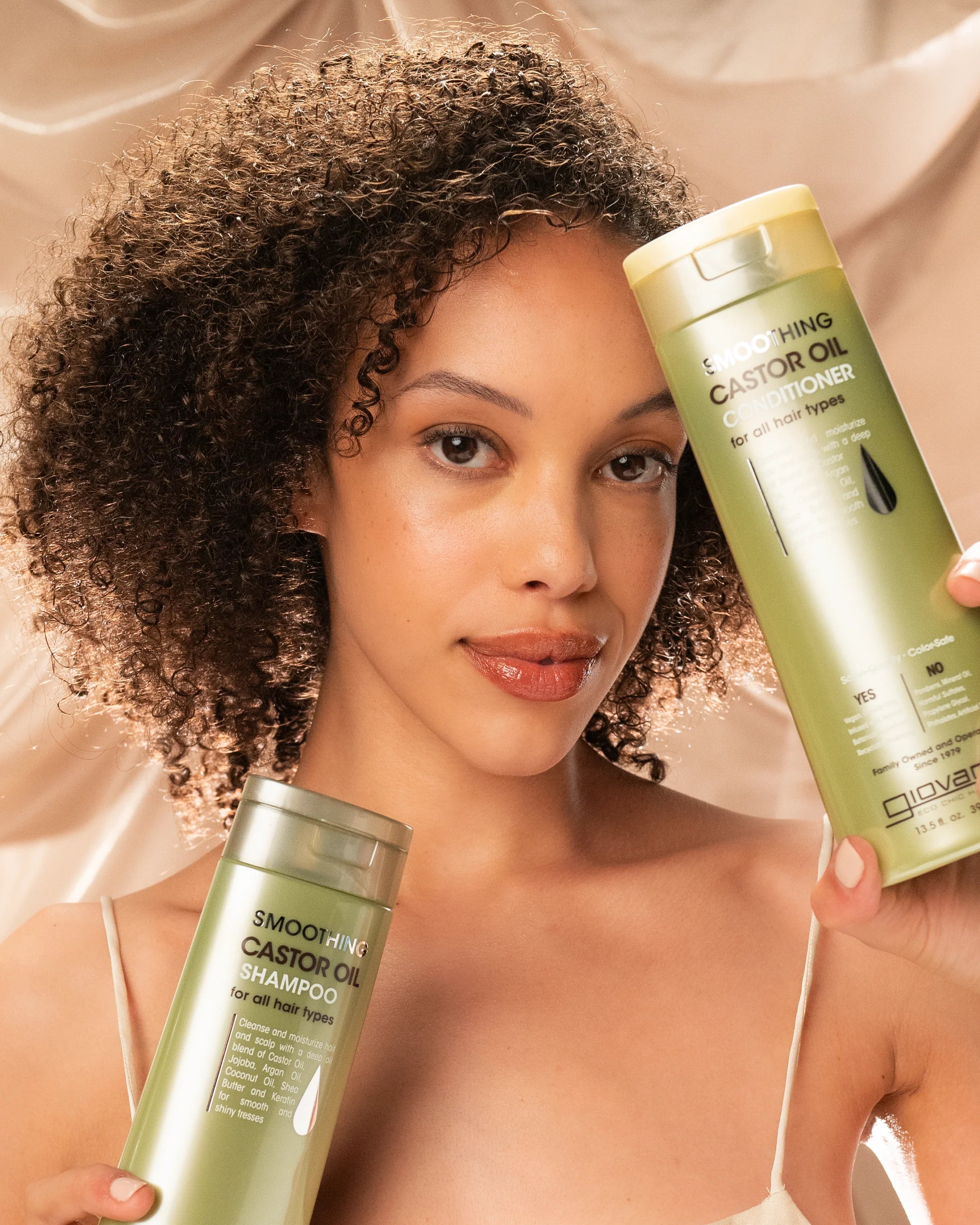 Model toont Giovanni Cosmetics -Smoothing Castor Oil Conditioner -399ml en shampoo, perfecte combinatie voor glanzend, glad haar. Geschikt voor CG-methode en alle haartypes.