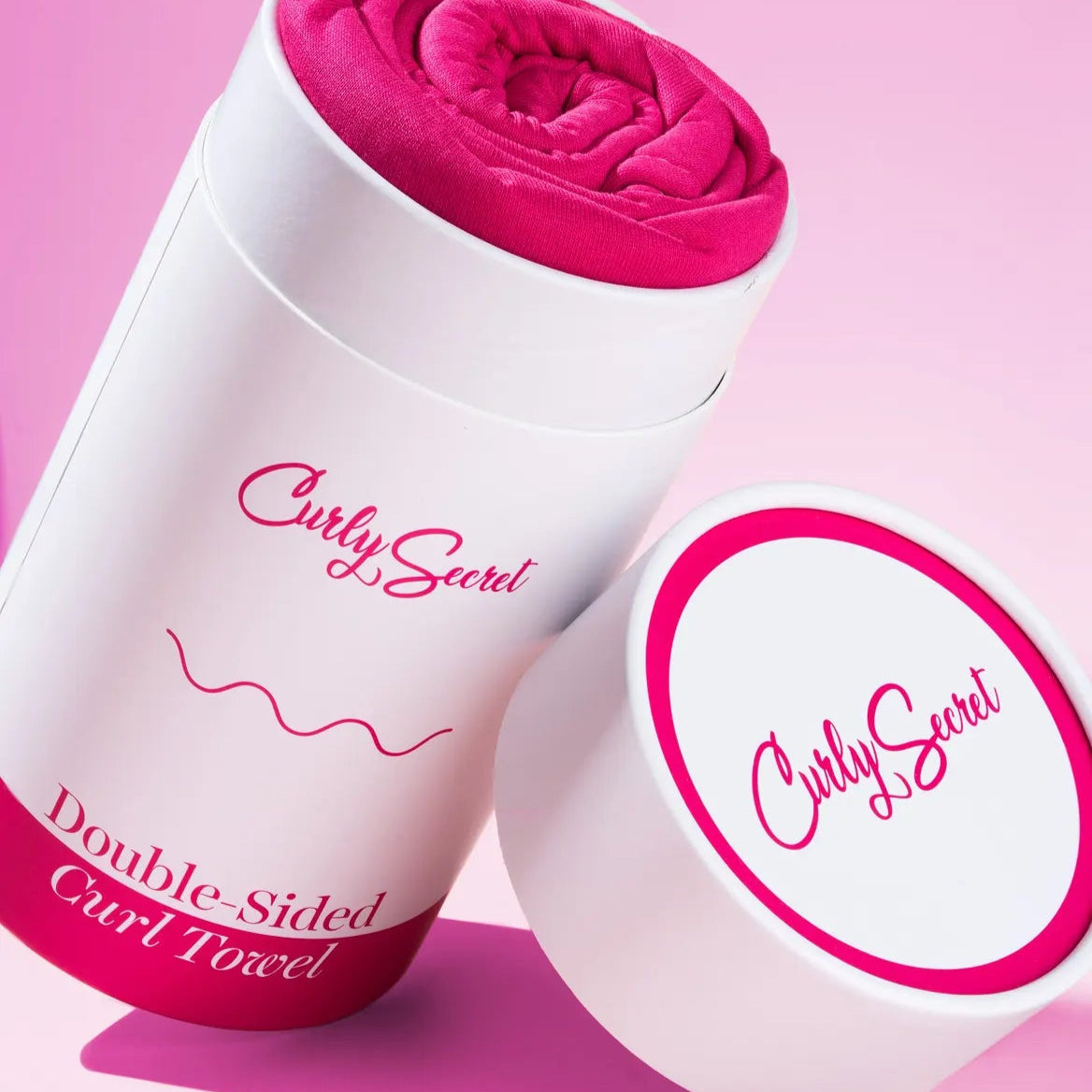 Verpakking van Curly Secret Dubbelzijdige Krul handdoek met opgerolde microvezel doek in felle roze kleur, ideaal voor krulverzorging.