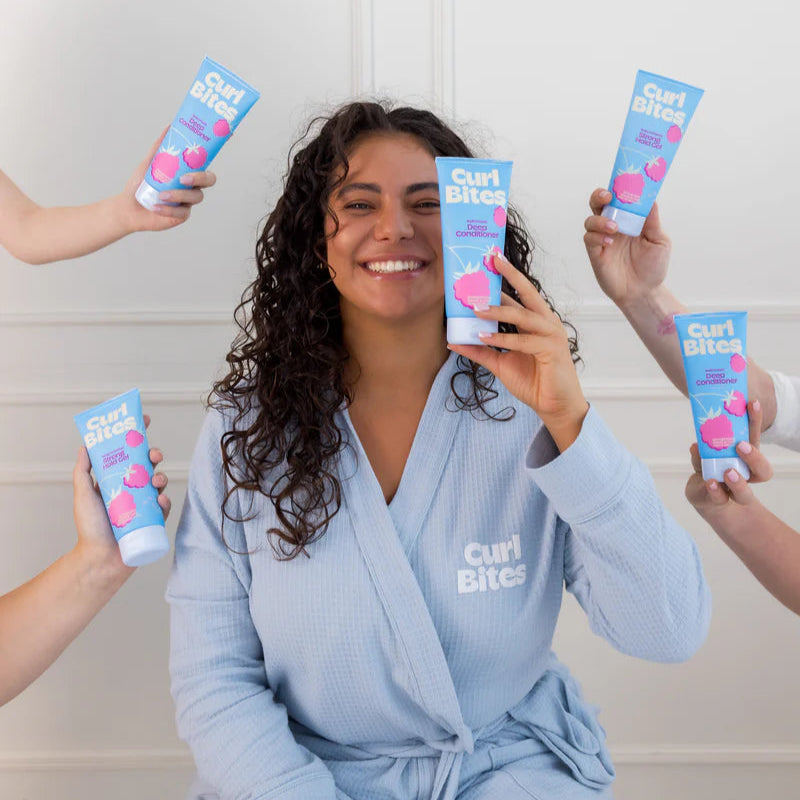 Vrouw met krullend haar toont Curl Bites - Multi-Proteïn Deep Conditioner 200ml, omringd door handen met hetzelfde product.