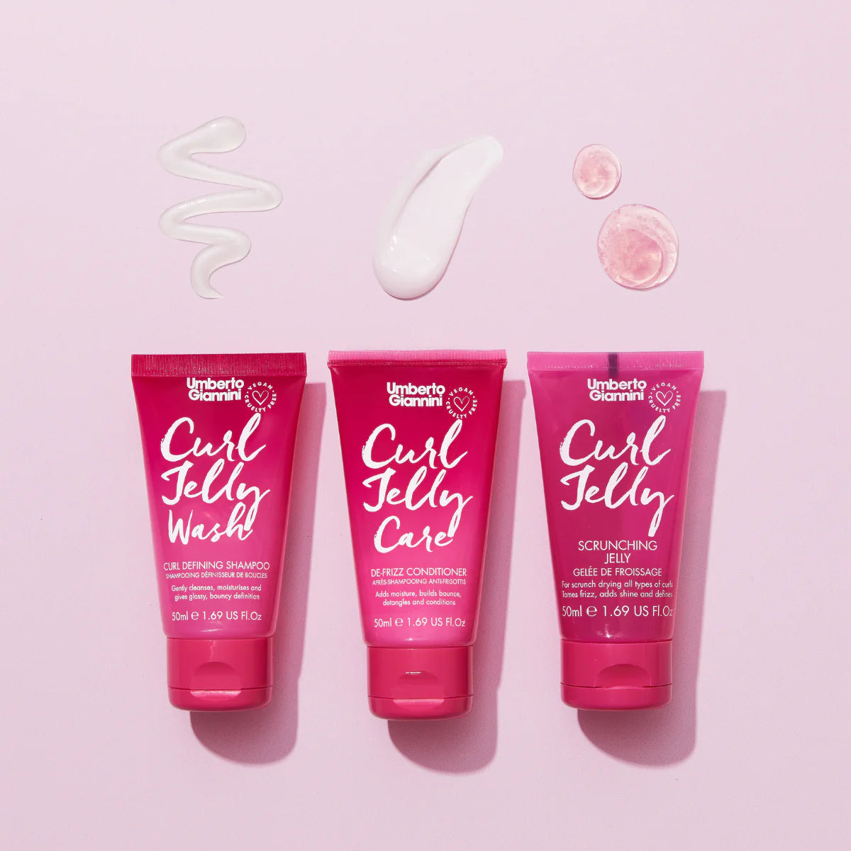 Set van drie Umberto Giannini Curl Jelly producten op roze achtergrond met texturen, perfect voor CG-vriendelijke krulverzorging in travel size.