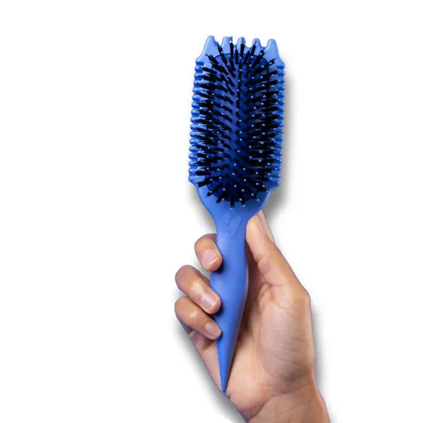 Hand houdt blauwe Bounce Curl Volume EdgeLift Brush vast, perfect voor het creëren van volume en het definiëren van krullen.
