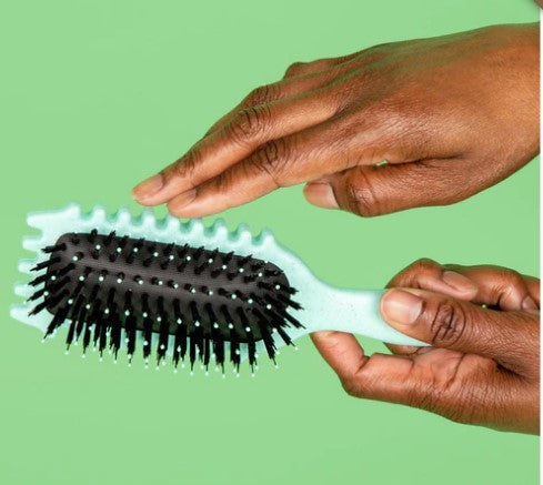 Handen demonstreren de flexibiliteit van de Bounce Curl Define Edgelift Styling Brush in mintgroen, perfect voor kruldefinitie.