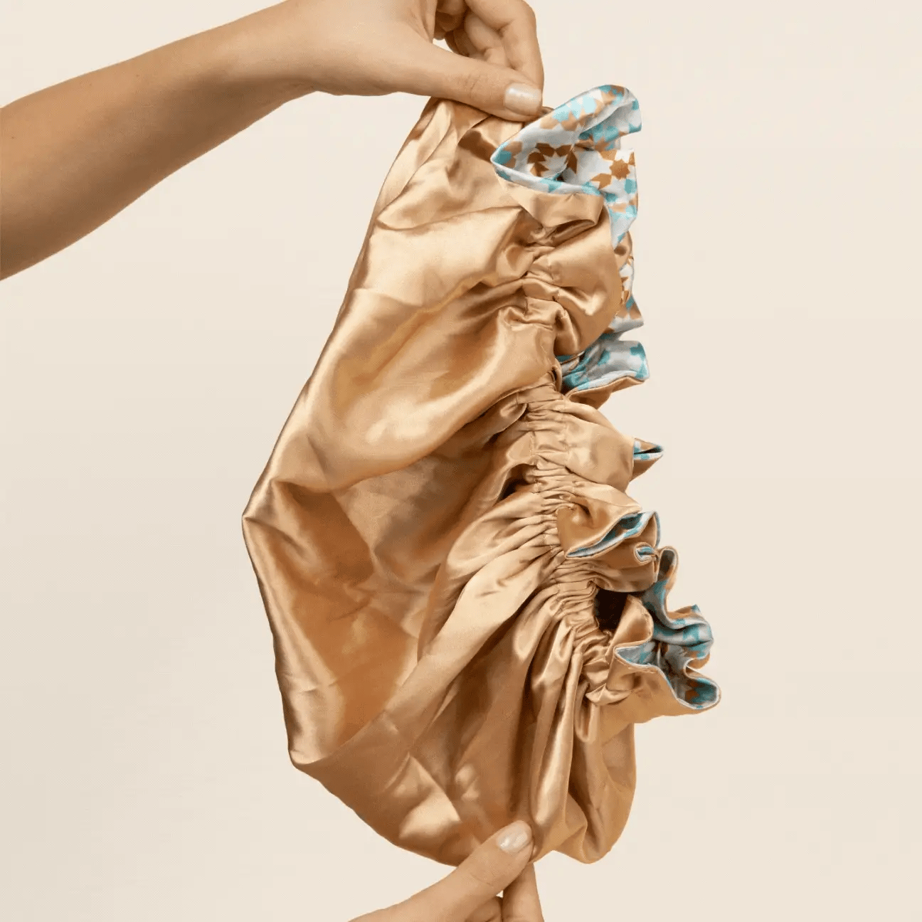 Reversible Satin Hair Bonnet van Bounce Curl in goudkleurige zijde, toont de binnenzijde van de satijnen haaraccessoire voor krullen.