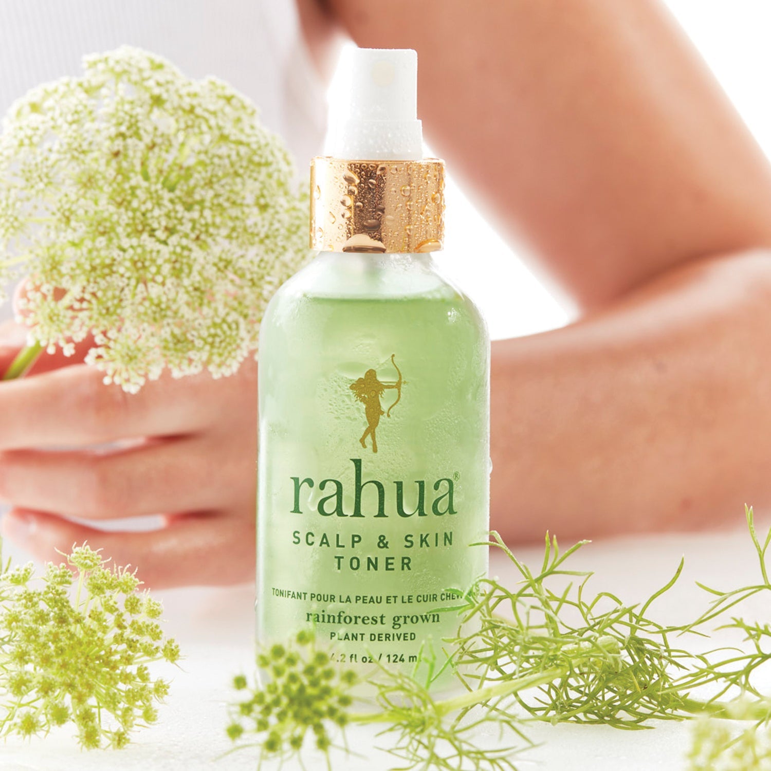 Rahua Scalp & Skin Toner – Verfrissende vegan toner met aloë en komkommer, gepresenteerd met bloemen op achtergrond voor natuurlijke uitstraling.