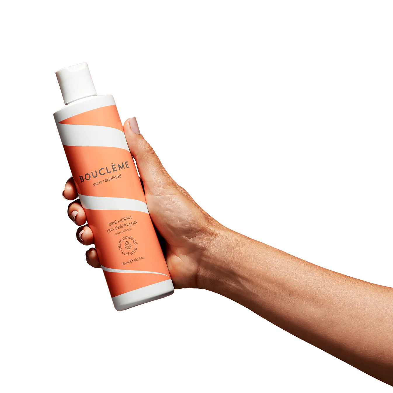 Hand houdt Bouclème Seal & Shield Curl Defining Gel 300ml vast, toont ergonomisch ontwerp van de fles. Bekroonde styling gel voor krullend haar.