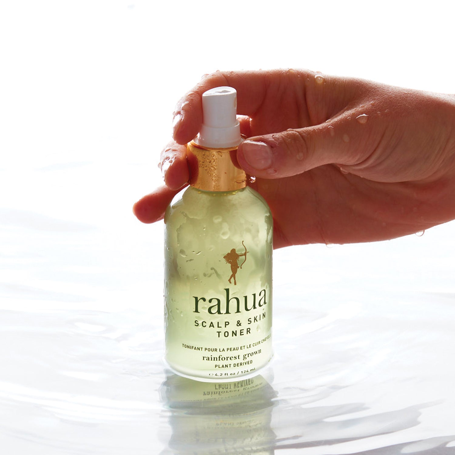 Rahua Scalp & Skin Toner – Hydraterende haartoner in hand boven water, benadrukt verkoelende werking en natuurlijke ingrediënten zoals Rahua-olie.