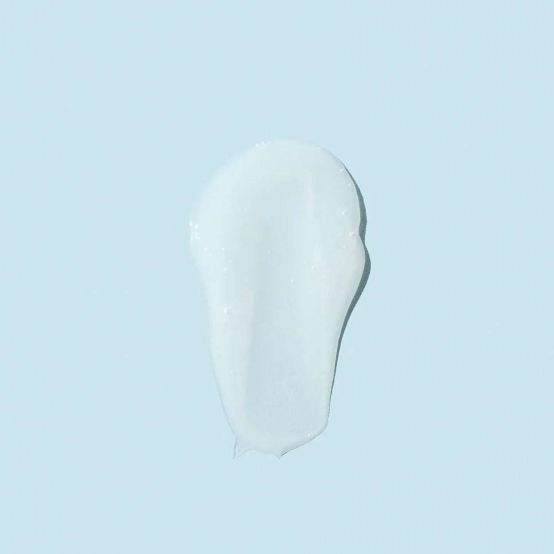 Textuur van de As i Am Dry & Itchy Olive & Tea Tree Oil Shampoo, romige witte formule voor gevoelige hoofdhuidverzorging.