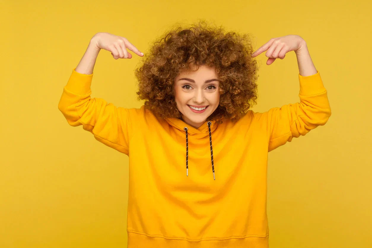 Woman with curly hair points to her nice curls