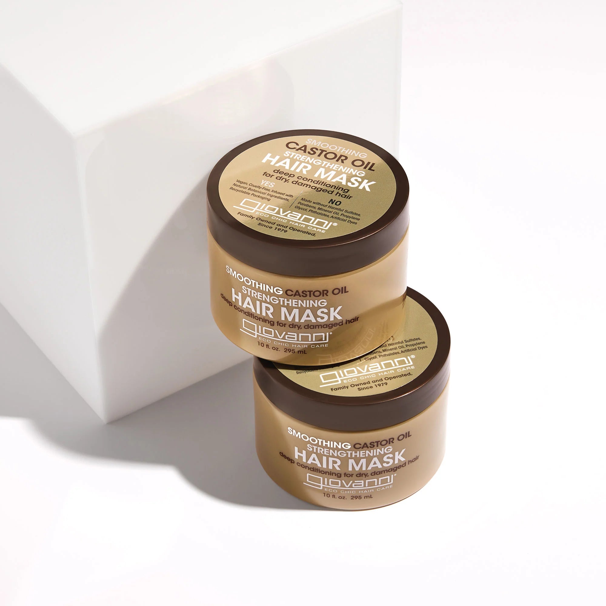 Twee Giovanni Cosmetics Castor Oil Strengthenig Haarmaskers 295ml gestapeld op witte achtergrond, perfect voor diepe haarverzorging.