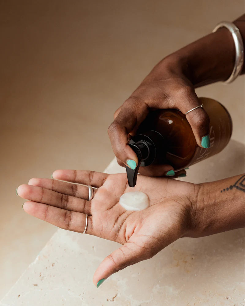 Hand pompt Holy Curls, Curl Gel, 300 ml op de handpalm, toont textuur van de styling gel voor perfecte kruldefinitie.