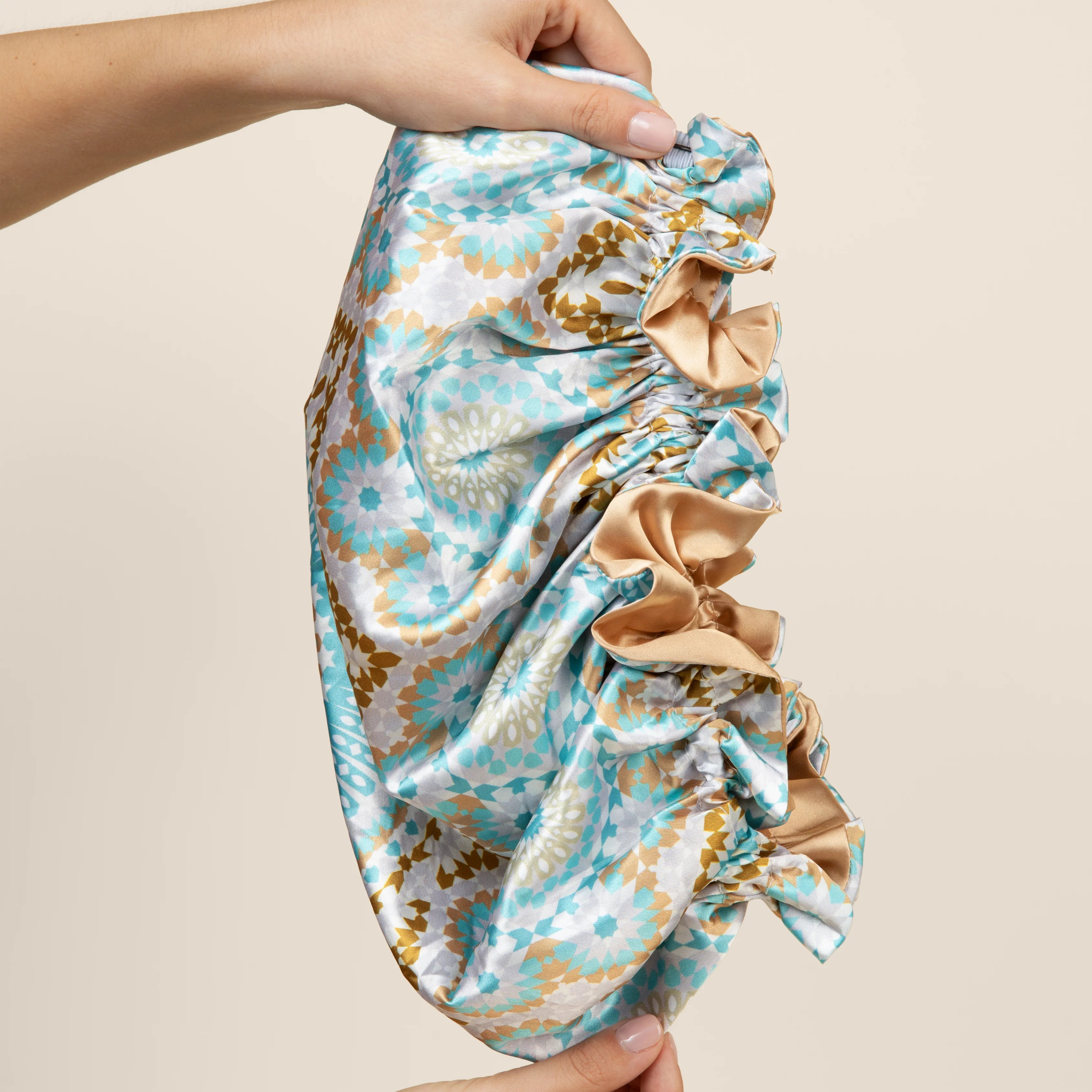 Bounce Curl Reversible Satin Hair Bonnet met kleurrijk patroon aan de ene zijde, ontworpen om krullen te beschermen en haarbreuk te verminderen.